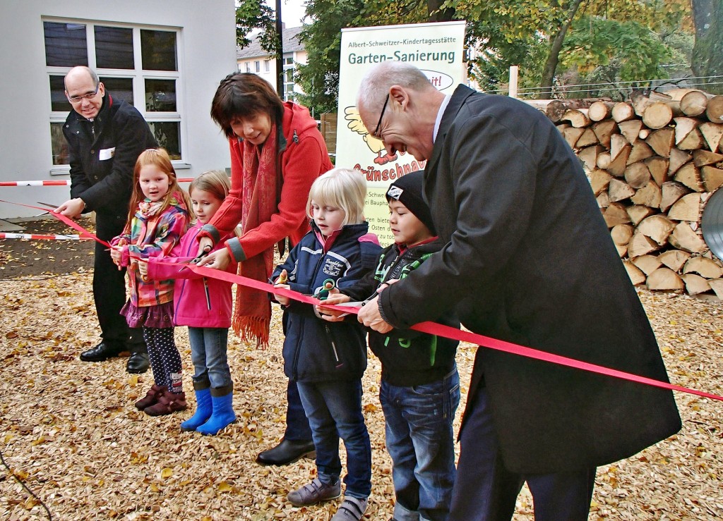  Durchschneiden des roten Bandes: v.rechts: Oberbürgermeister Dr. Ivo Holzinger, Kindergarten-Leiterin Franziska Kiebler, Pfarrer Holger Scheu, dazwischen je ein Kind aus den vier Gruppen des Kindergartens.