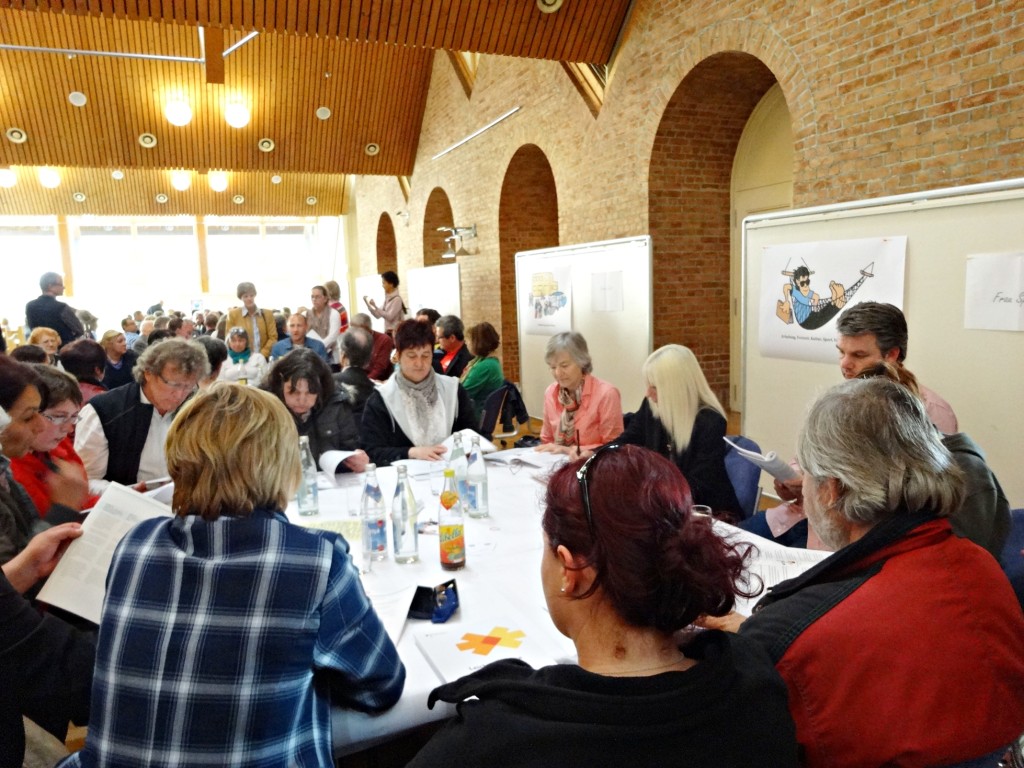 an den Tischen im Foyer wurde eifrig diskutiert Die acht Diskussionsrunden im Foyer waren so voll besetzt, dass einige Teilnehmer nur noch Stehplätze fanden. Besonders frequentiert war der Tisch zum Thema „Frühforderung, Schule und Bildung“. 